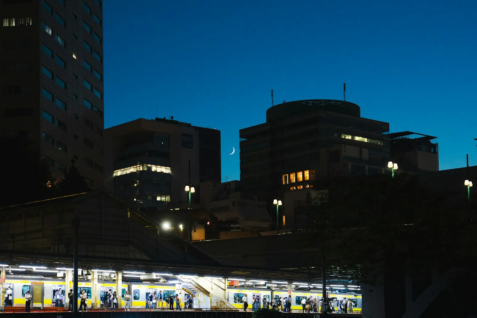 A railway station in Tokyo lit up at night.