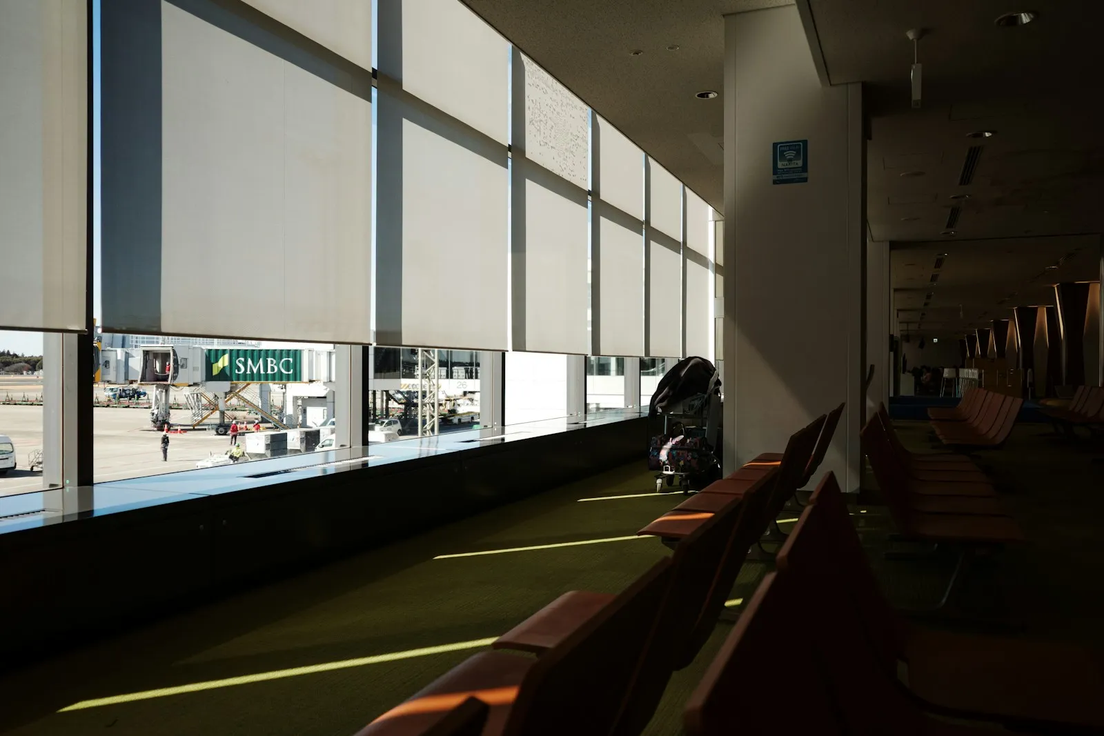 A departure lounge at Narita Airport, with the tarmac visible through the windows.