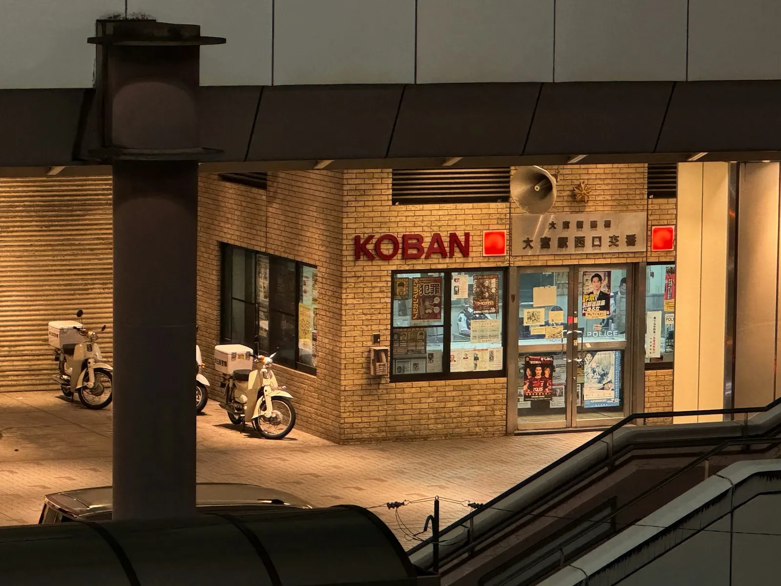 Two police scooters parked outside a Japanese koban police box.