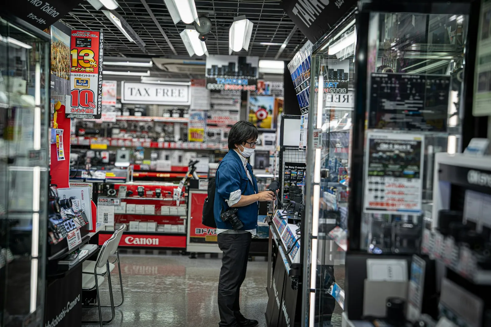 An aisle in a Japanese electronics store with a tax-free sign above the shelves.