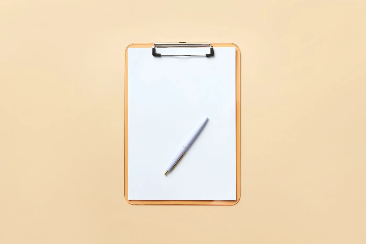 A blank clipboard with a white sheet of paper and a pen resting on it, against a plain cream background.