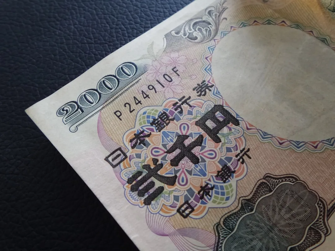 A close-up of the corner of a 2,000-yen Japanese banknote on a dark surface.